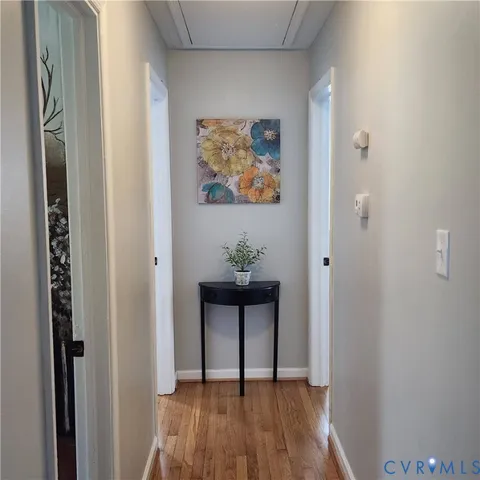 a view of a hallway with wooden floor and a window
