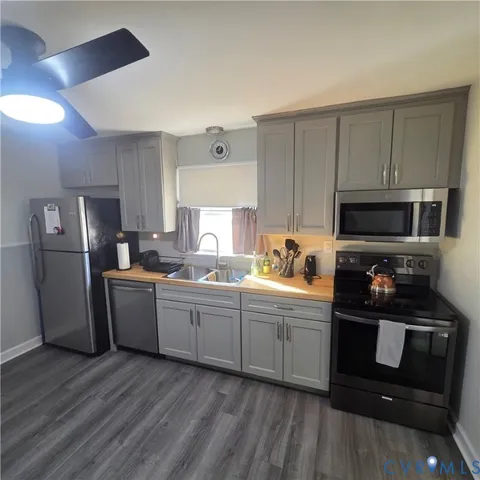 a kitchen with stainless steel appliances granite countertop a refrigerator a stove top oven a sink and dishwasher