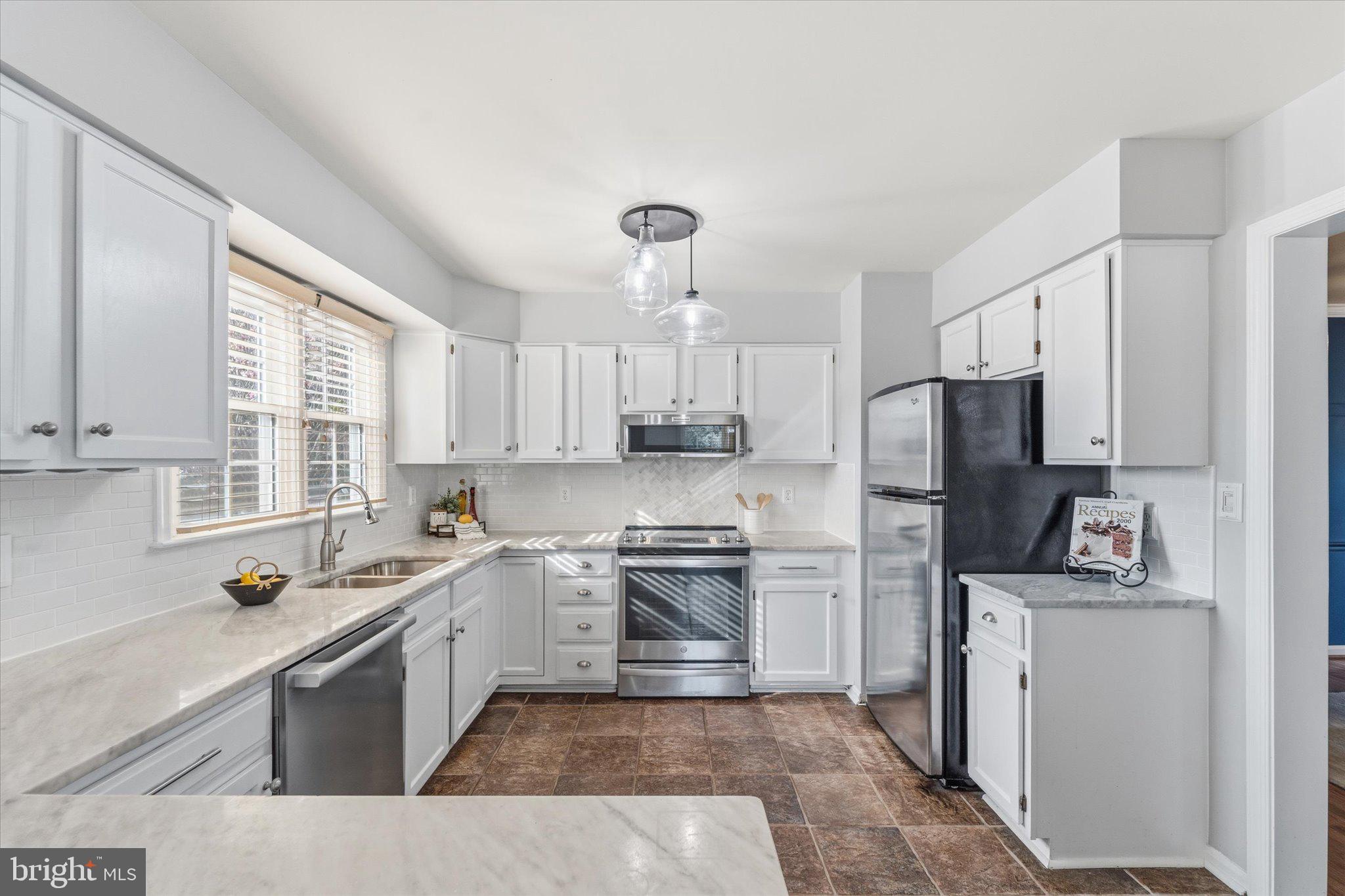 43451 Livery Square Ashburn, VA 20147 - Photo 12 of 51 a kitchen with a sink a window a refrigerator and stainless steel appliances
