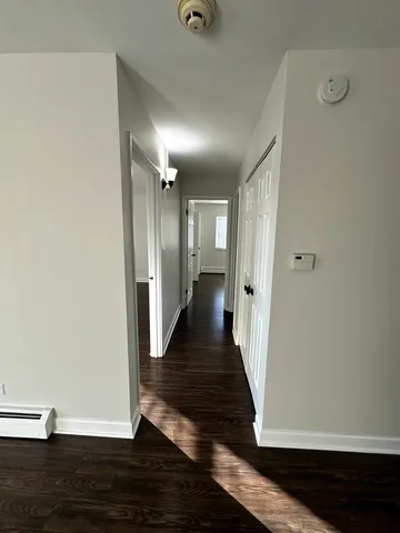 a view of a hallway with wooden floor