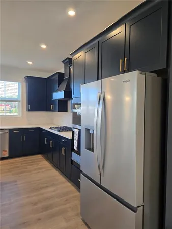 a kitchen with stainless steel appliances granite countertop a refrigerator and a cabinets