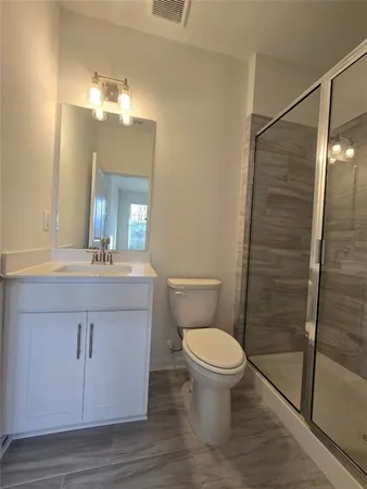 a bathroom with a sink a toilet a mirror and shower