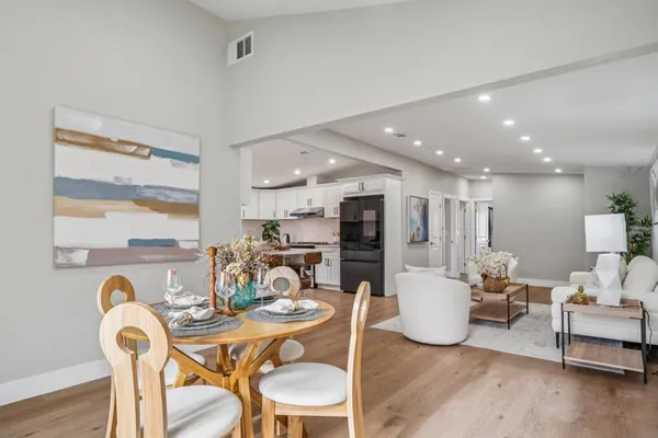 a living room with furniture a rug and kitchen view