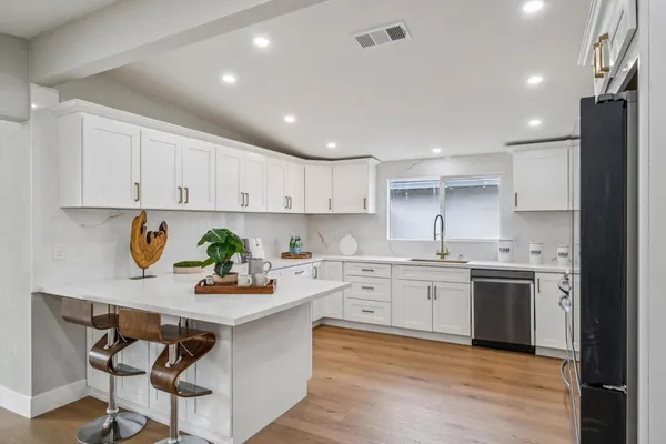 a kitchen with white cabinets stainless steel appliances and sink