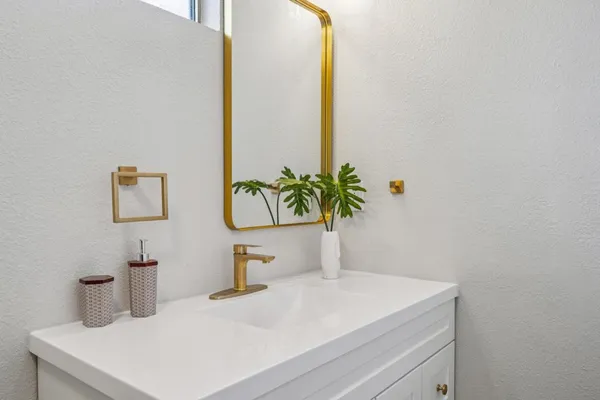 a bathroom with a sink a vanity and a mirror