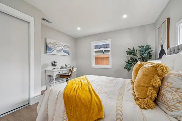 a bed sitting in a bedroom next to a window