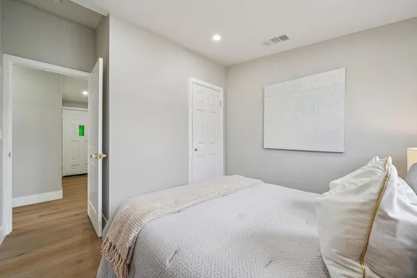 a bedroom with a bed and a painting on the wall