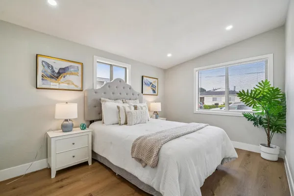 a spacious bedroom with a large bed and a potted plant