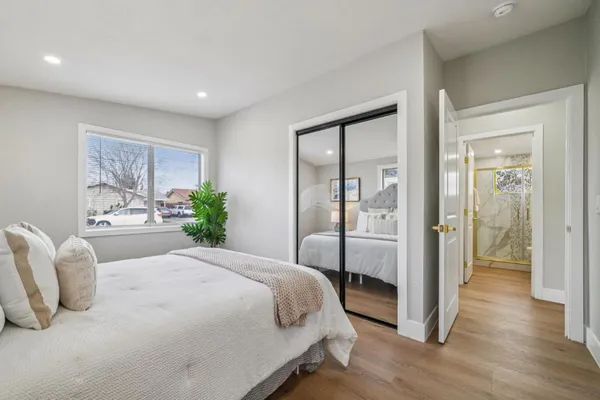 a bedroom with a bed and wooden floor