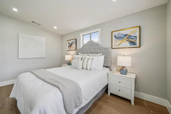 a bedroom with a bed and a painting on the wall