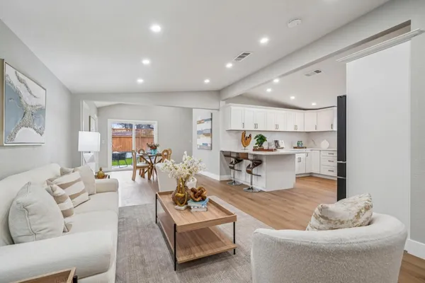 a living room with furniture and kitchen view