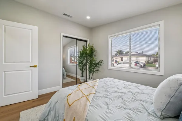a bedroom with a bed and a large window