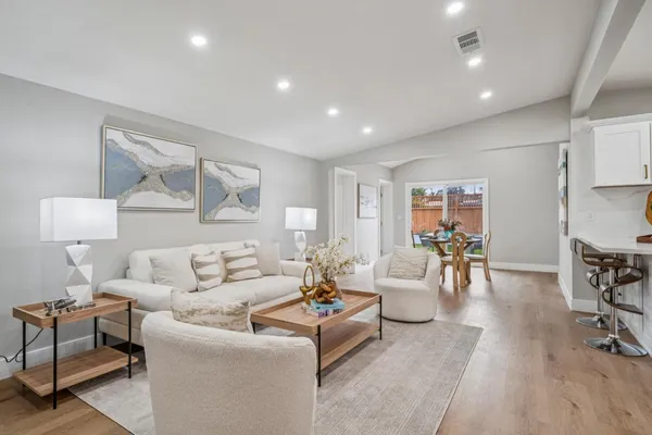 a living room with furniture and a wooden floor