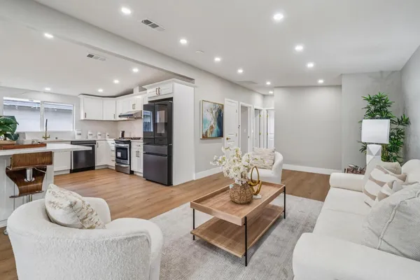 a living room with furniture kitchen view and a refrigerator