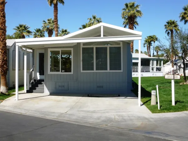 a front view of a house with a garden and yard