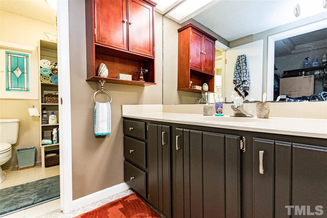 4339 Southwind Drive Raleigh, NC 27613 - Photo 16 of 24 a bathroom with a sink a vanity and a large mirror