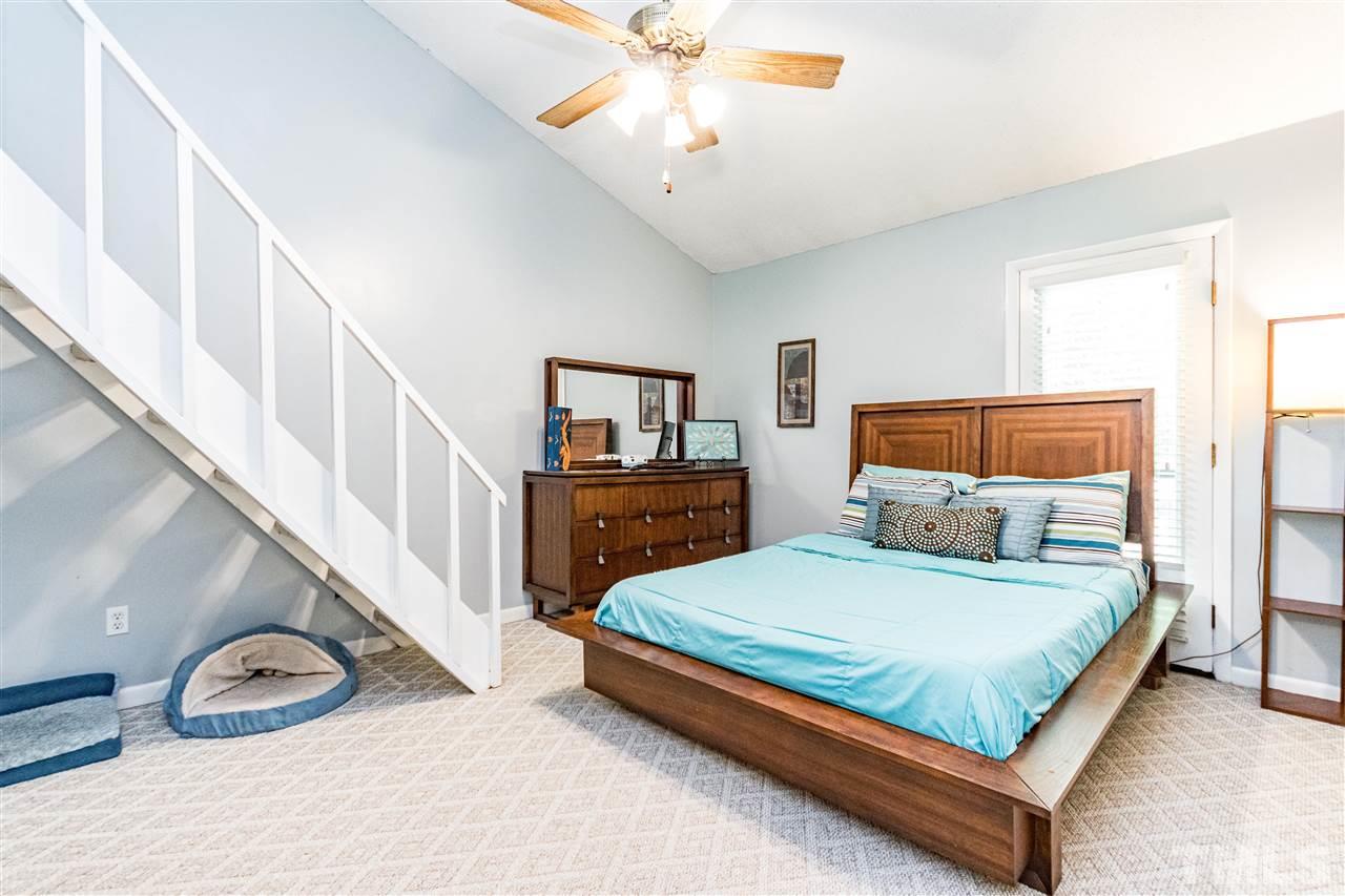 4339 Southwind Drive Raleigh, NC 27613 - Photo 17 of 24 a bedroom with a bed a lamp and a chandelier