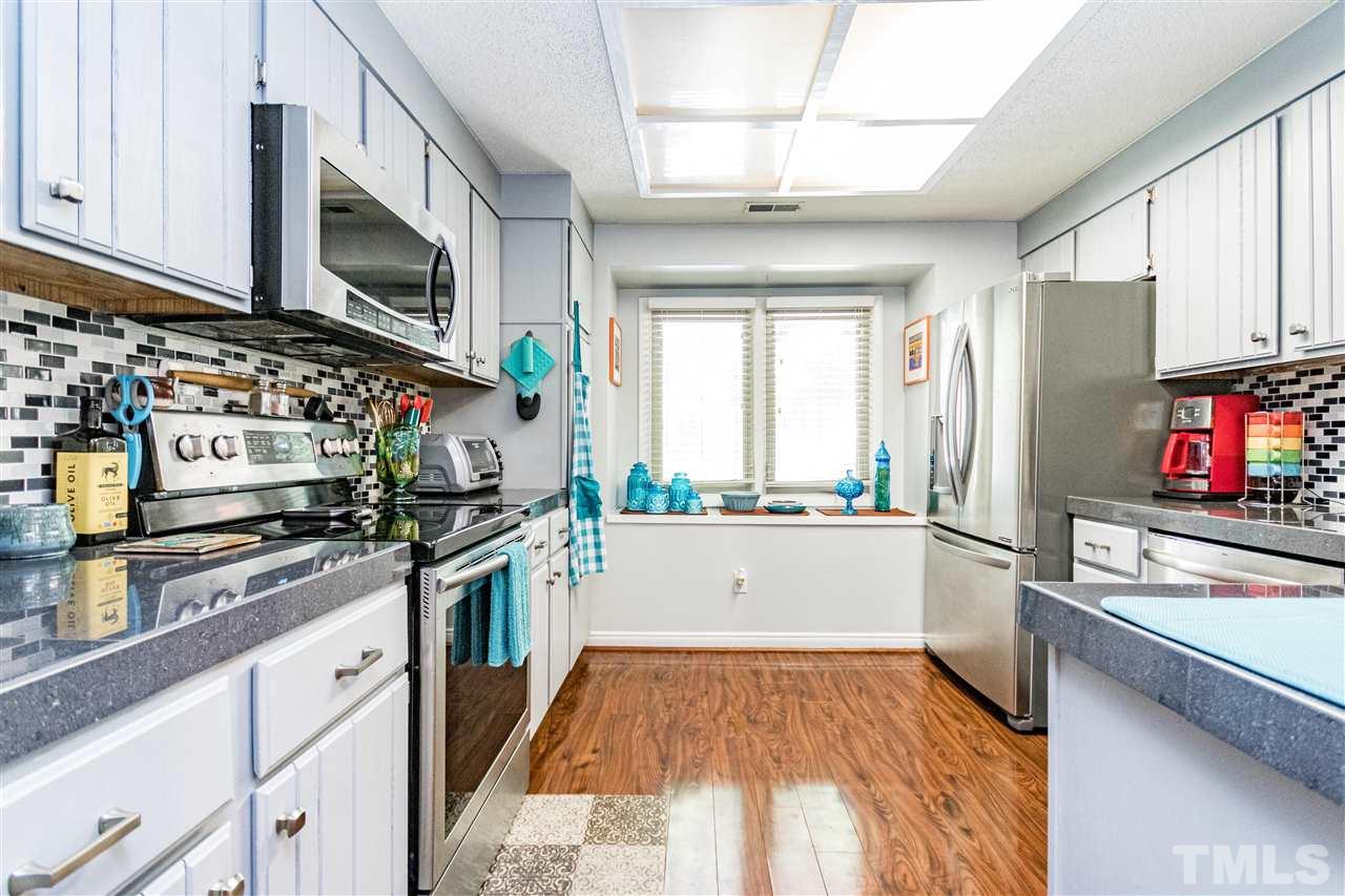 4339 Southwind Drive Raleigh, NC 27613 - Photo 5 of 24 a kitchen with stainless steel appliances a stove refrigerator sink and microwave
