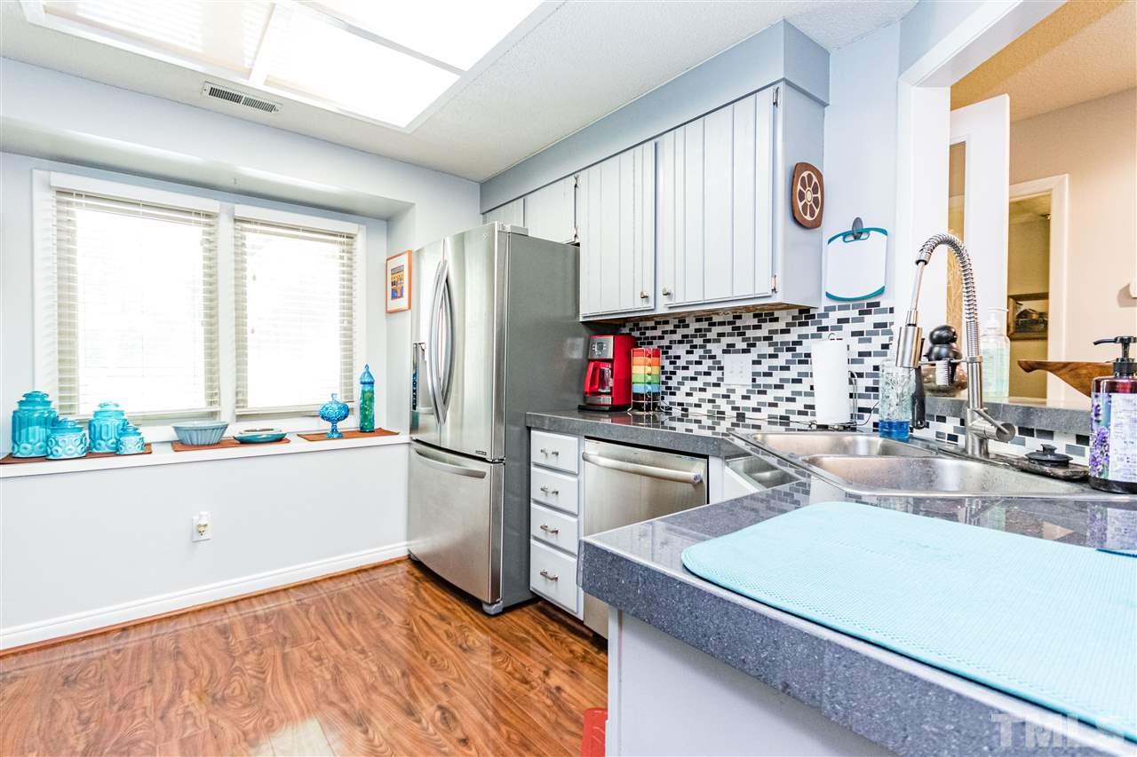 4339 Southwind Drive Raleigh, NC 27613 - Photo 6 of 24 a kitchen with stainless steel appliances kitchen island granite countertop a stove and a sink
