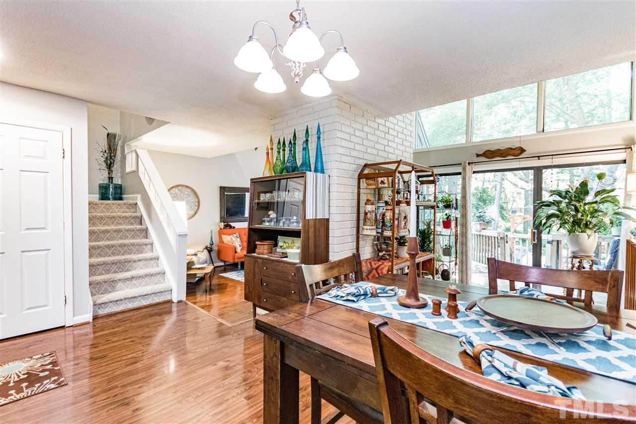 4339 Southwind Drive Raleigh, NC 27613 - Photo 8 of 24 a view of a dining room with furniture a chandelier and large windows