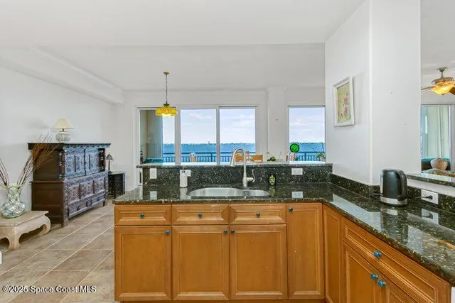 a kitchen with stainless steel appliances granite countertop a stove top oven a sink dishwasher a dining table and chairs with wooden floor