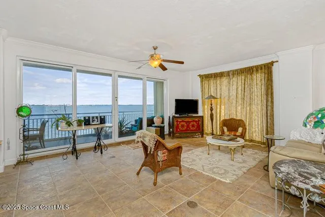 a living room with furniture a flat screen tv and a floor to ceiling window