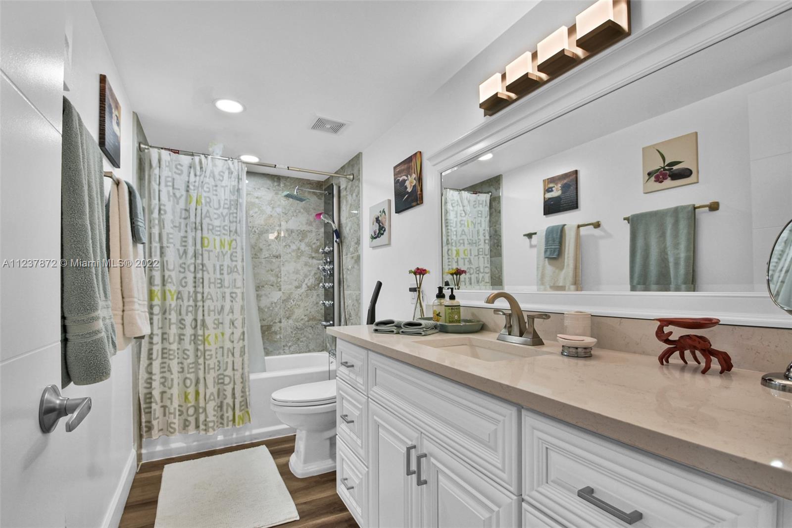 South Central Beach Hollywood, FL 33019 - Photo 17 of 30 a bathroom with a double vanity sink toilet and shower