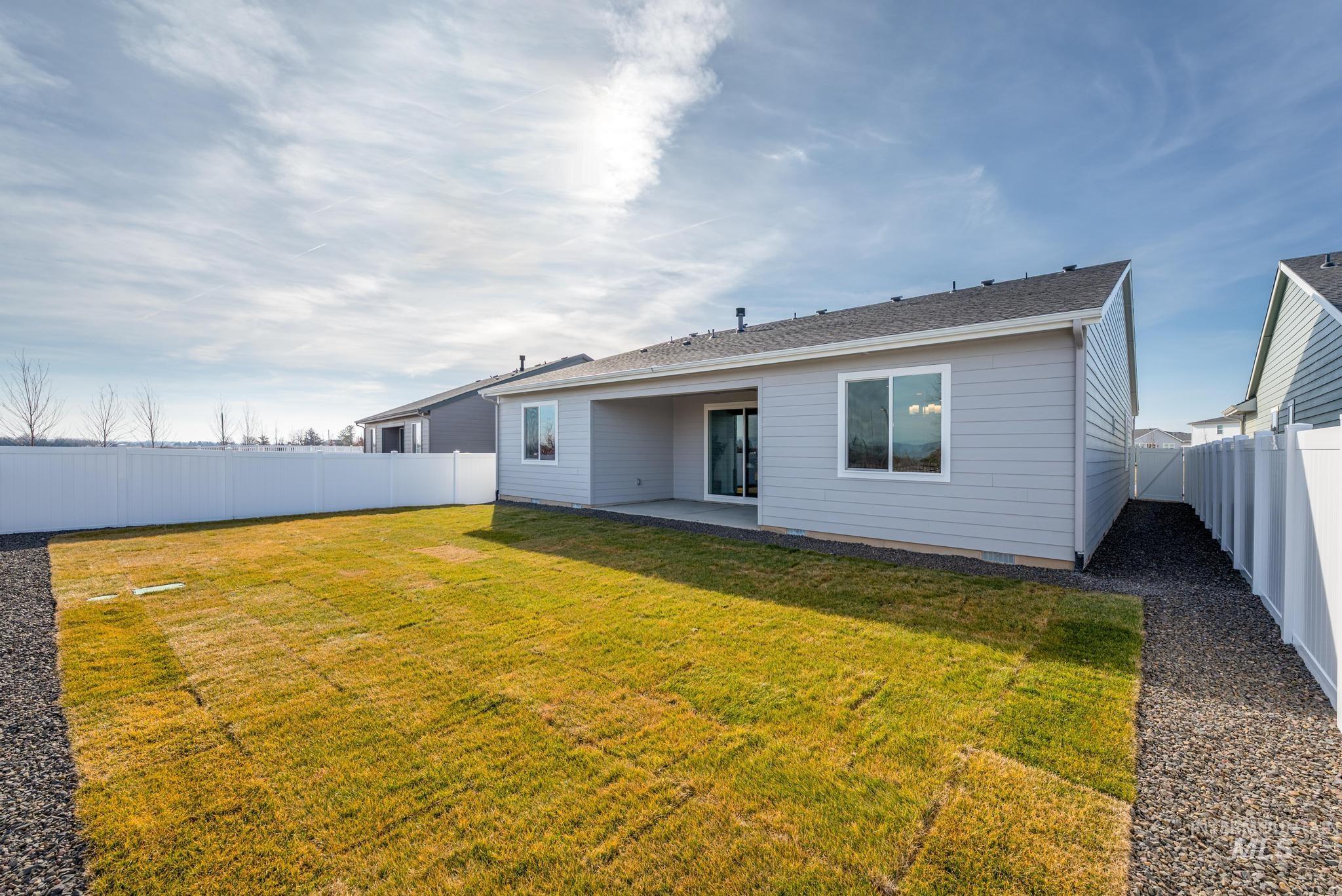 1925 Buckbrush Avenue Middleton, ID 83644 - Photo 11 of 20 Spacious backyard featuring a manicured lawn, full vinyl privacy fencing, a covered concrete patio, light-colored siding, and a dark shingle roof