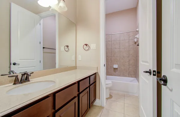 a bathroom with a granite countertop sink a toilet and shower