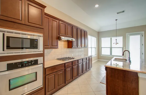 a kitchen with stainless steel appliances granite countertop a stove microwave and cabinets