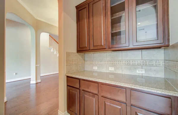 a view of a kitchen with granite countertop white cabinets and a wooden floor
