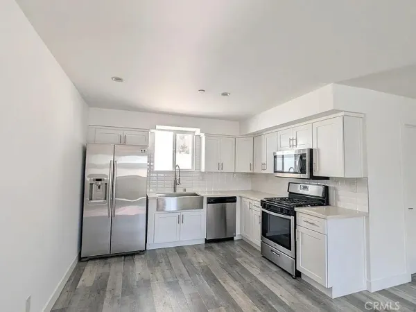 a kitchen with white cabinets and white appliances