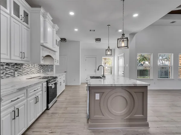 a kitchen with sink stove and cabinets
