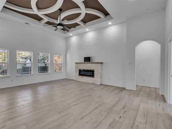 a view of an empty room with a fireplace and wooden floor