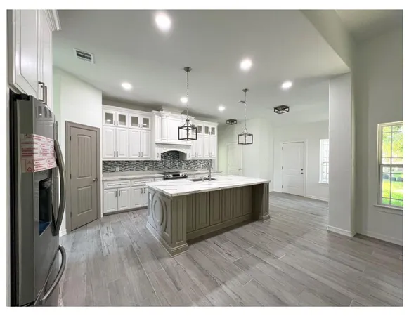 a kitchen with stainless steel appliances granite countertop a stove a refrigerator a sink and a oven