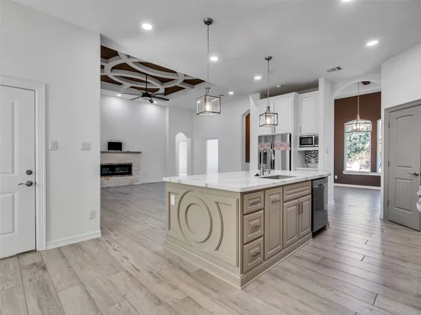a kitchen with stainless steel appliances granite countertop a lot of counter space and wooden floors