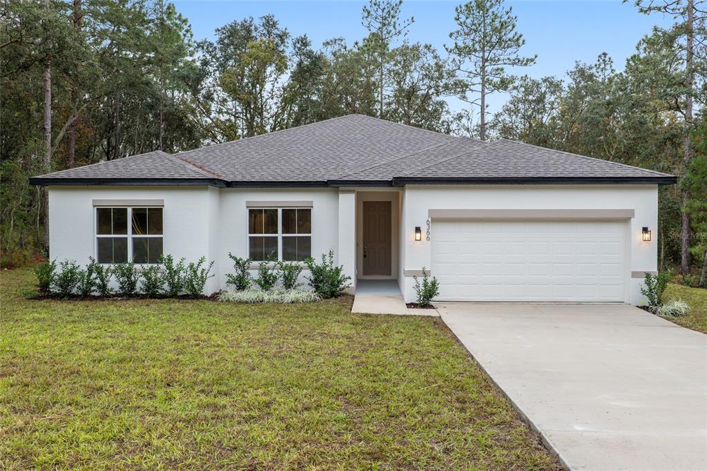 6366 Southwest 153rd Ln Road Ocala, FL 34473 - Photo 1 of 1 a front view of a house with a yard and garage
