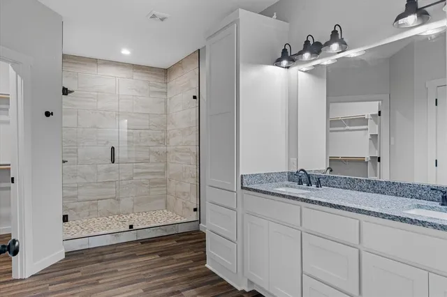 a bathroom with a granite countertop sink mirror and shower