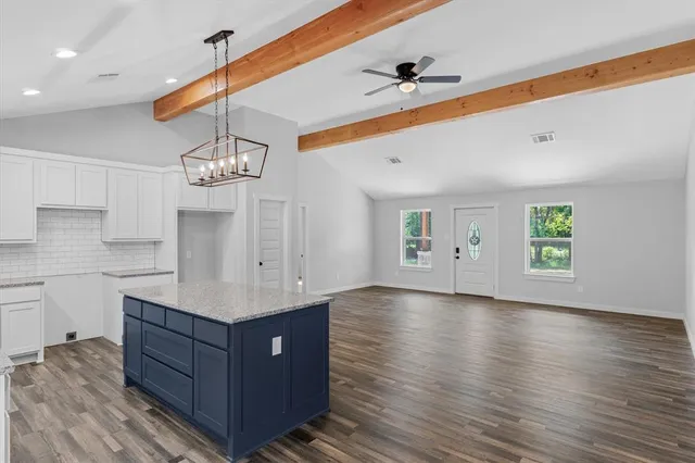 a kitchen with stainless steel appliances granite countertop a sink and wooden floor