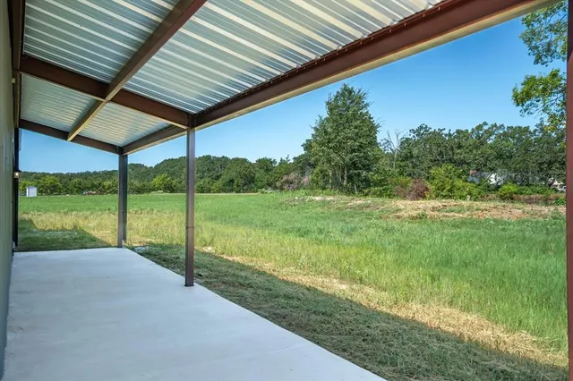 a view of a patio with a table chairs and a backyard