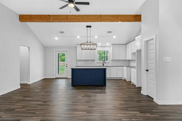 a large kitchen with stainless steel appliances kitchen island a refrigerator sink and cabinets