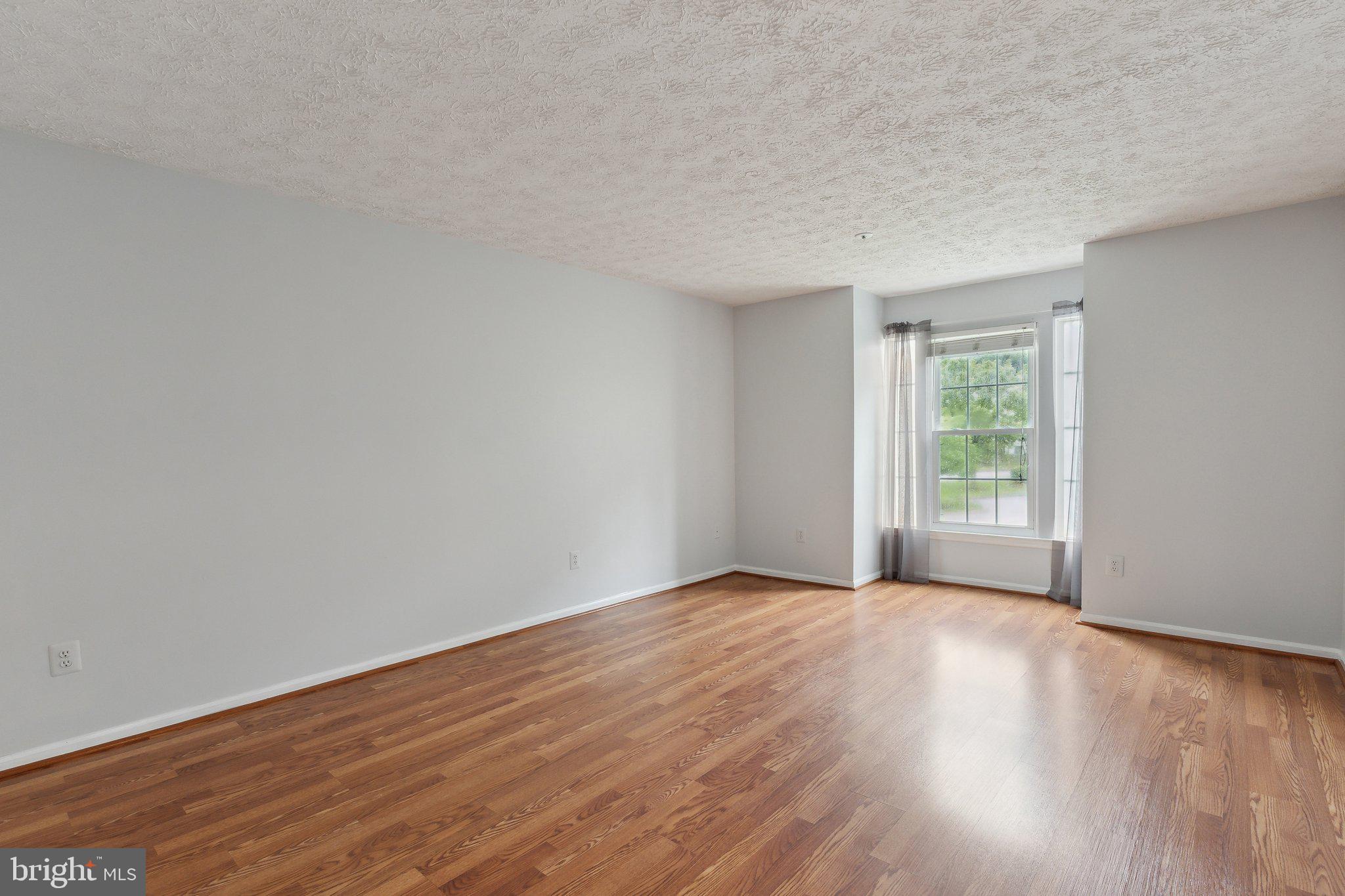 815 Deering Road, Unit 7H Pasadena, MD 21122 - Photo 15 of 24 a view of an empty room with wooden floor and a window