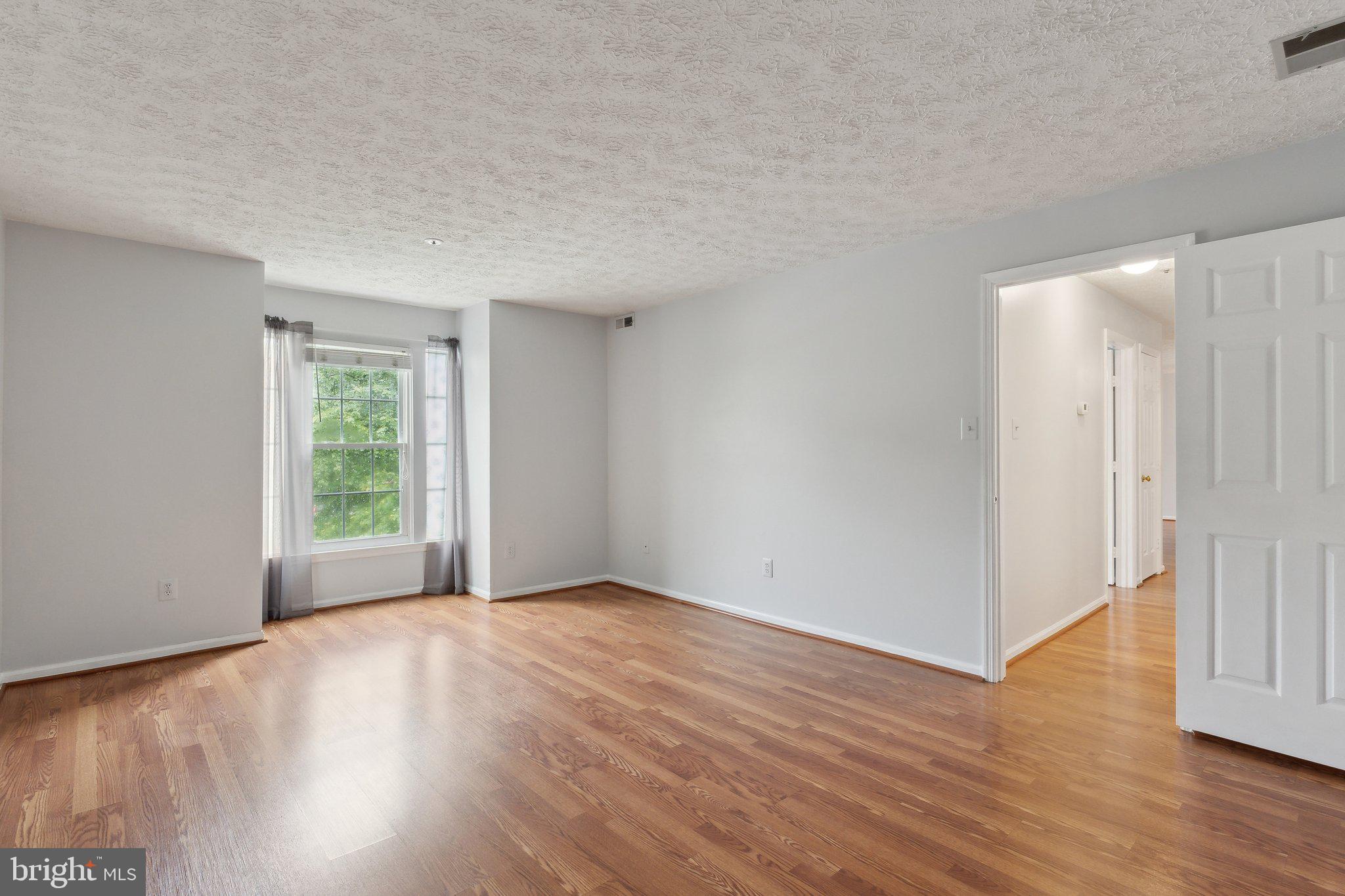 815 Deering Road, Unit 7H Pasadena, MD 21122 - Photo 17 of 24 a view of an empty room with wooden floor and a window