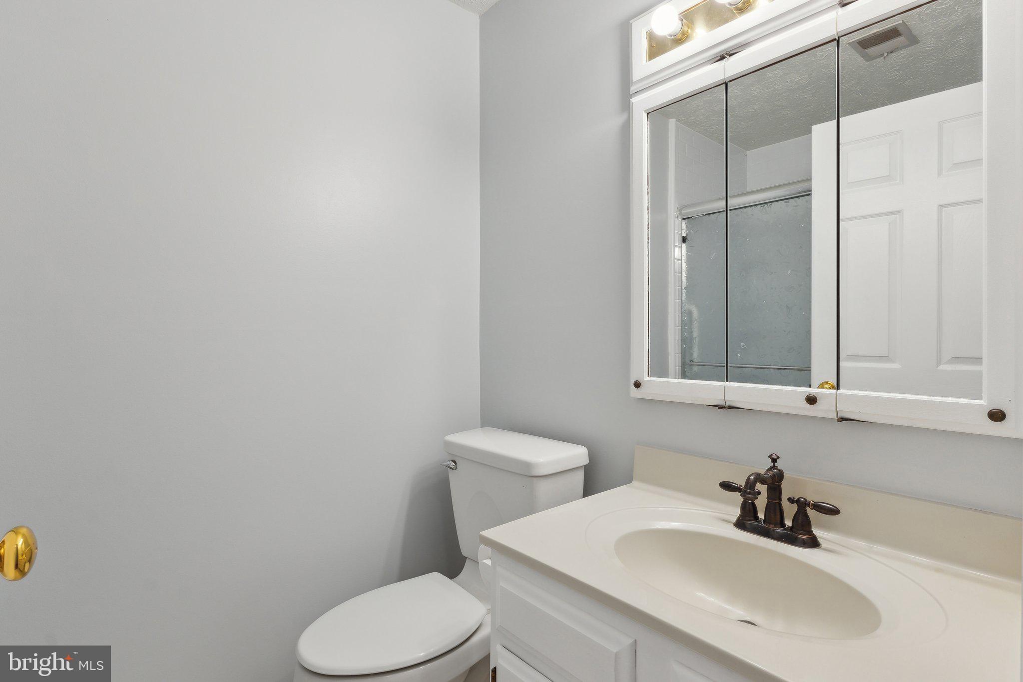 815 Deering Road, Unit 7H Pasadena, MD 21122 - Photo 18 of 24 a bathroom with a sink a toilet and mirror