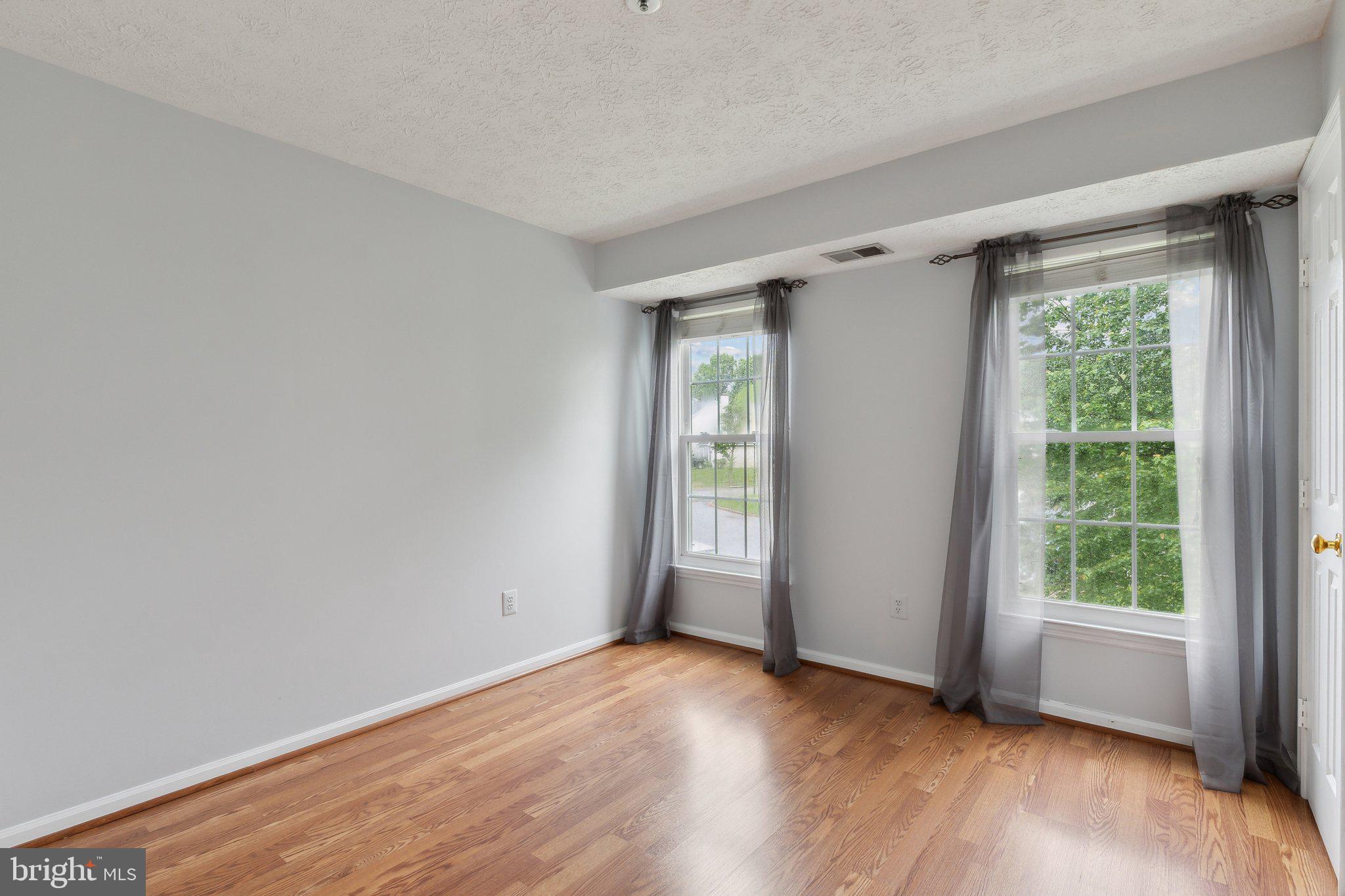 815 Deering Road, Unit 7H Pasadena, MD 21122 - Photo 20 of 24 a view of an empty room with wooden floor and a window