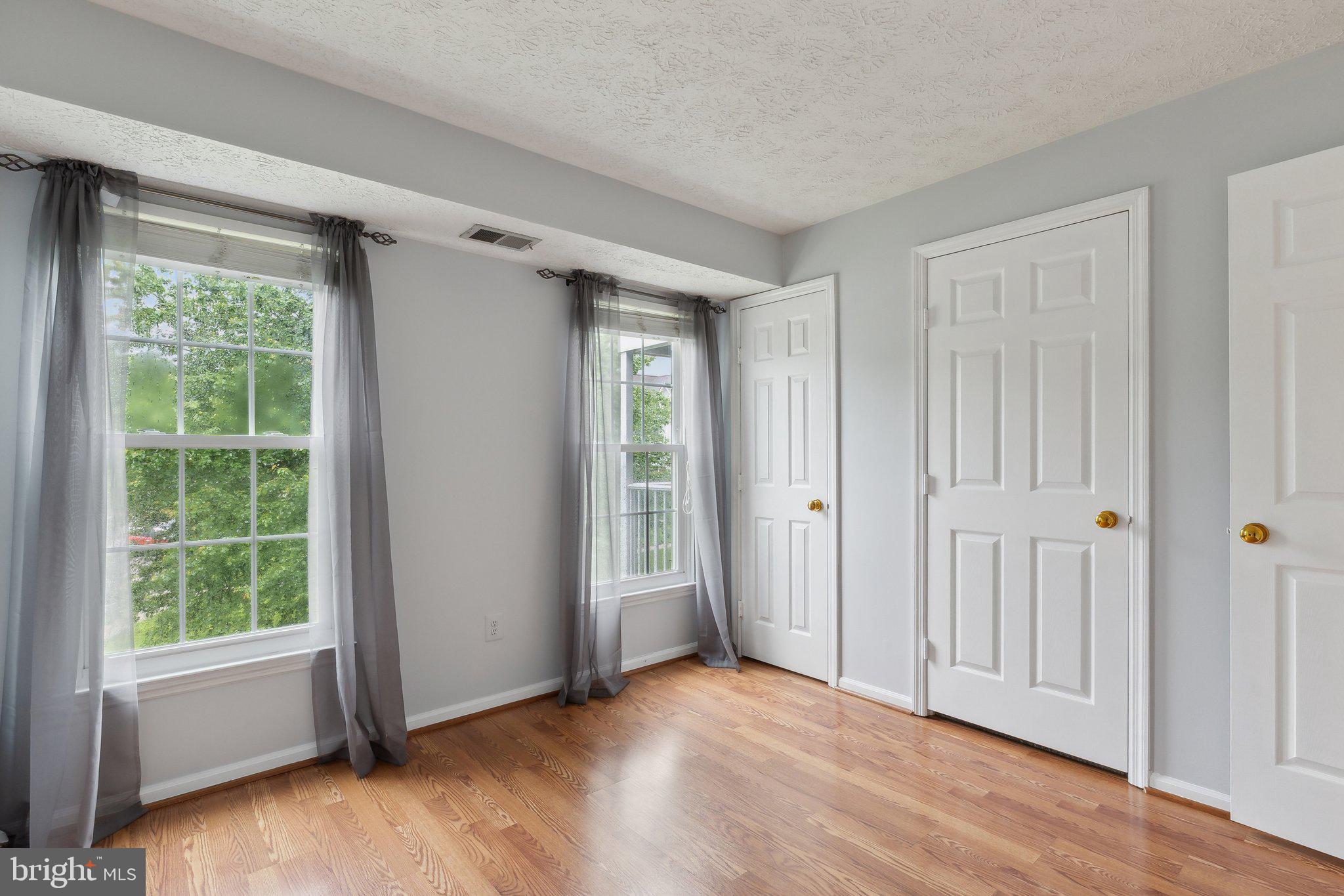 815 Deering Road, Unit 7H Pasadena, MD 21122 - Photo 21 of 24 a view of an empty room with a window and wooden floor