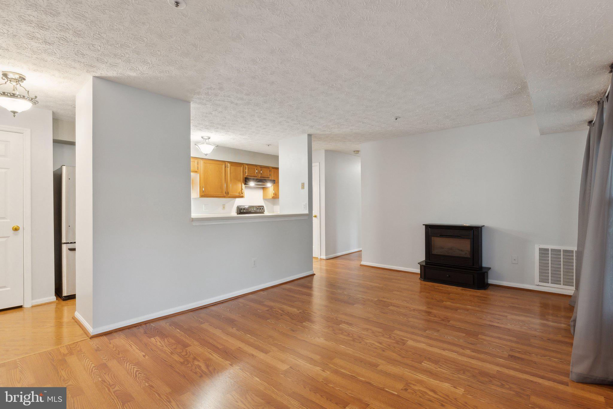815 Deering Road, Unit 7H Pasadena, MD 21122 - Photo 3 of 24 a view of an empty room with wooden floor and a window