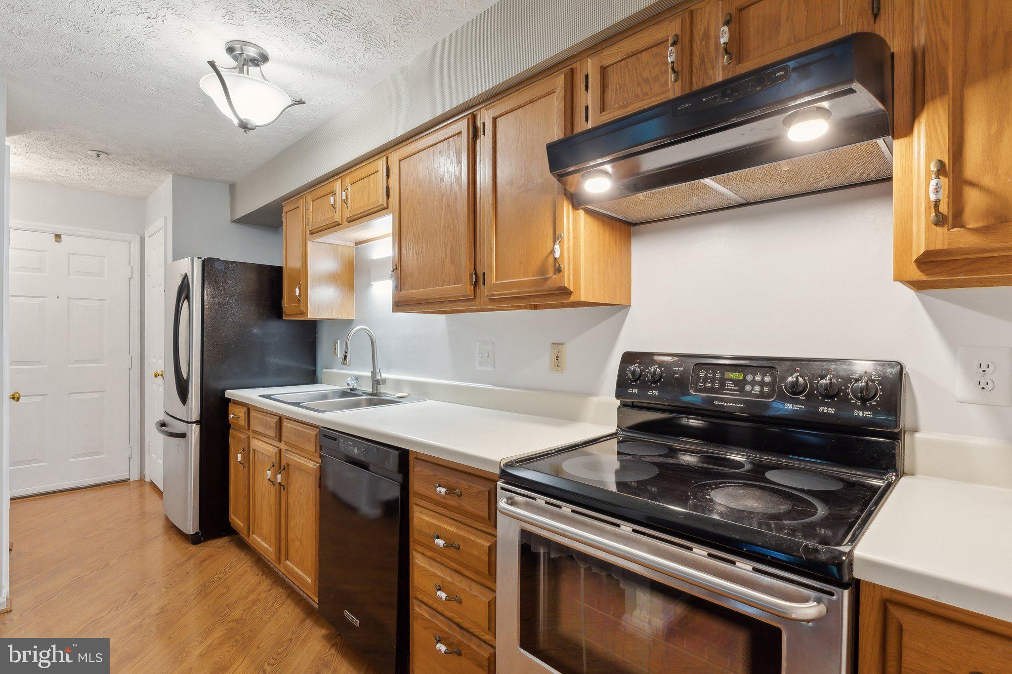 815 Deering Road, Unit 7H Pasadena, MD 21122 - Photo 5 of 24 a kitchen with stainless steel appliances granite countertop a stove and a refrigerator