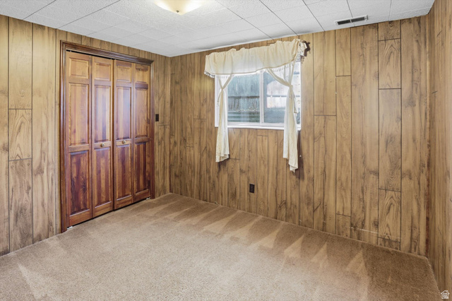 380 North 200 West Logan, UT 84321 - Photo 18 of 29 Bedroom with carpet flooring, a closet, and wood walls