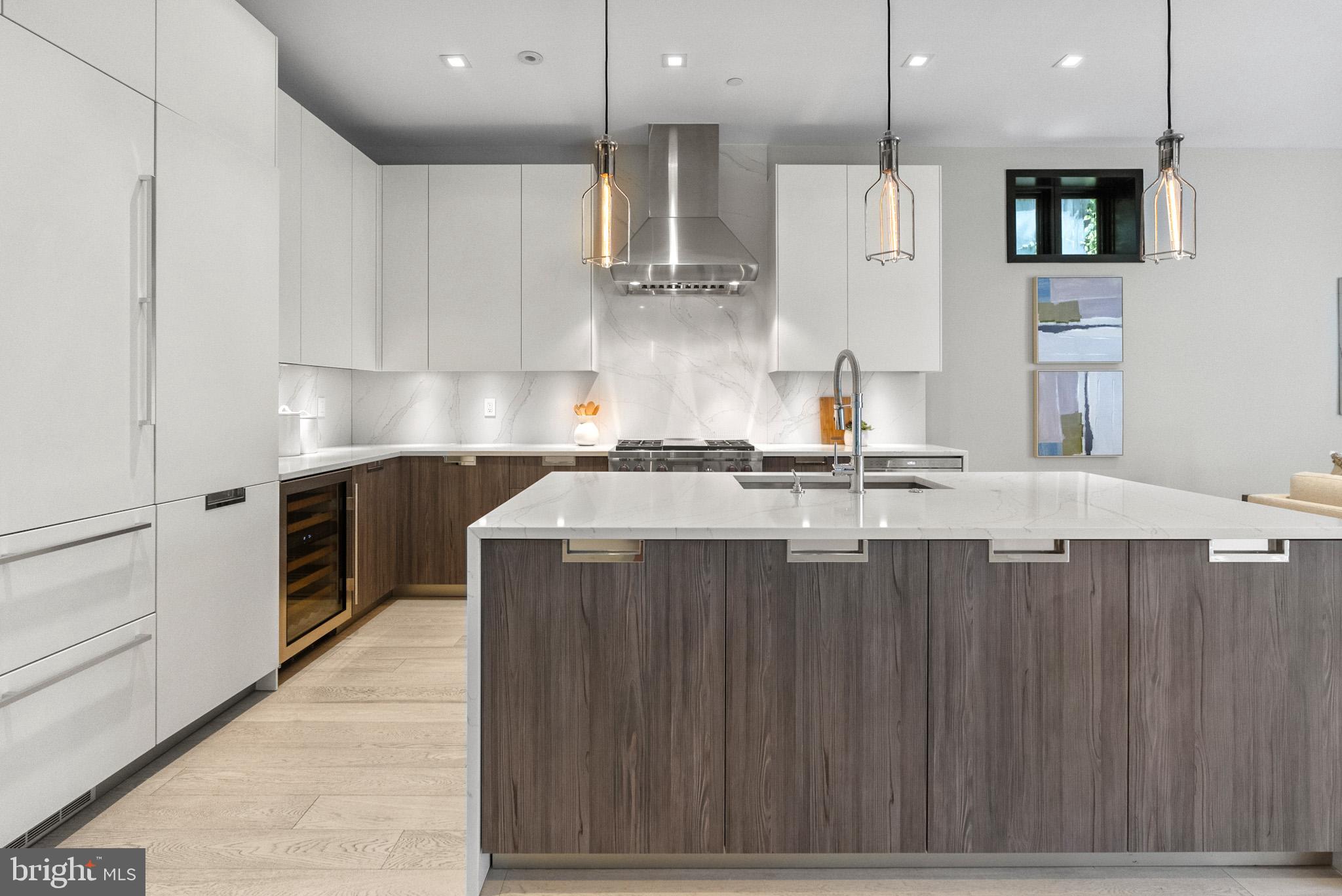 1310 Q Street Northwest, Unit 4 Washington, DC 20009 - Photo 9 of 24 a kitchen with kitchen island granite countertop a sink a counter top space stainless steel appliances and cabinets